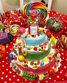 a birthday cake with lots of candies and lollipops on the table