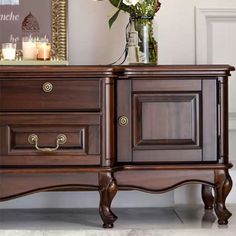 a wooden dresser with two drawers and candles on the top one drawer has flowers in it