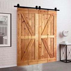 an open wooden door in a room with white brick wall and black metal legs on the floor