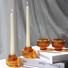 three candles sitting on top of two books