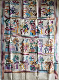 an old cloth with colorful designs and people on it's sides, hanging from a wall