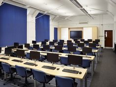 an empty classroom with rows of desks and computers