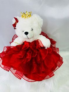 a white teddy bear wearing a red dress