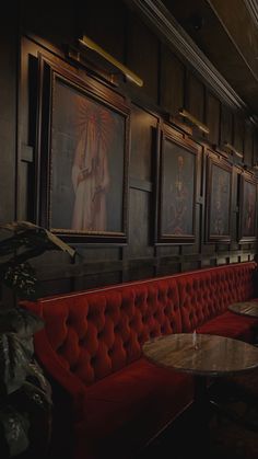 an empty restaurant with red booths and paintings on the wall