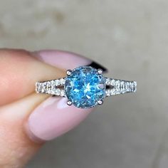 A stunning aquamarine and diamond ring featuring a 1.37 carat round cut aquamarine set in prongs. Round brilliant cut diamonds are set along the shoulders. This ring is handcrafted in 18k white gold.
The measurements of the aquamarine are approximately 7.00mm x 7.00mm x 5.06mm.
This ring can be resized to any finger size at no extra cost.
Ready to Make It Yours? Contact us to reserve this ring and to get more info! Luxury Aquamarine Diamond Ring With Prong Setting, Aquamarine Diamond Ring With Diamond Accents, Light Blue Aquamarine Diamond Ring With Center Stone, Light Blue Diamond Rings With Prong Setting, Light Blue Round Cut Diamond Jewelry, Fine Jewelry Light Blue Diamond Ring With Center Stone, Light Blue Diamond Ring With Brilliant Cut, Light Blue Diamond Ring With Center Stone, Gia Certified Blue Topaz Ring With Diamond