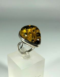 Discover the timeless elegance of our Spectacular Green Amber Ring, expertly crafted for ladies in stunning 925 sterling silver. This exquisite piece features natural Baltic Sea amber, renowned for its unique beauty and healing properties. Perfect for any occasion, this amber ring will add a touch of sophistication to your jewelry collection. Product Details: Material: 925 Sterling Silver Stone: Natural Baltic Sea Amber Color: Spectacular Green Design: Minimalist Style Ring Size: Adjustable Size Ring Weight 6,62 grams Handcrafted: Yes For: Ladies/Women Key Features: Authentic Baltic Amber: Each ring is made with genuine amber sourced from the Baltic Sea, ensuring quality and authenticity. Unique Design: The melting silver setting beautifully complements the amber, creating a one-of-a-kind Amber Open Ring For Anniversary, Silver Cabochon Rings Fine Jewelry, White Gold Rings With Shiny Finish For Gift, Sterling Silver Ring With Shiny Finish, Classic Amber Rings For Formal Occasions, Elegant Amber Cabochon Ring, Formal Amber Ring Jewelry, Amber Rings For Formal Occasions, Fine Jewelry, Timeless Rings With Shiny Finish As Gift