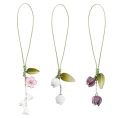 three necklaces with flowers hanging from them