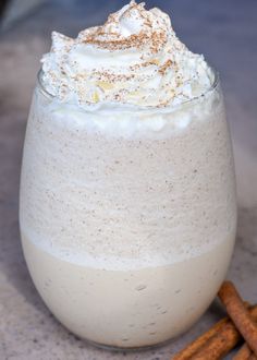 a glass filled with whipped cream and cinnamon sticks