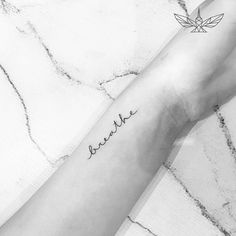 a woman's arm with the word breathe tattooed on her left forearm and hand