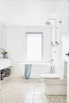 a white bathroom with a tub, toilet and sink