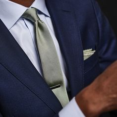 a man wearing a blue suit and green tie