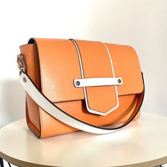 This leather bag, like all the others, uses our original ideas and handicrafts  Stylish and modern women handbag 🔥 Made of high quality smooth Italian leather in soft orange color. Lining made of natural Italian velor. Great combination inside and outside. The color scheme is perfect for a spring or summer look. The set includes 2 leather straps, one 60 cm for carrying in the hand or at the bend of the elbow, the second 120 cm for carrying on the shoulder or over the shoulder. 🔺Type: shoulder bag, crossbody bag, top handle bag 🔺Size: 25 * 18 * 12cm (9,8x7,1x4,72 inches) 🔺Belt Length: 120cm (47,25 inch) and 60 cm (23,6 inch) This model can be made in different colors of genuine leather.🌈 Lightweight and very comfortable bag. For any occasion. Add originality to your everyday style. Ins Orange Box Bag With Removable Pouch For Everyday Use, Modern Orange Shoulder Bag For Travel, Orange Shoulder Bag With Detachable Strap For Office, Trendy Orange Shoulder Bag With Leather Handles, Trendy Orange Leather Satchel, Orange Satchel Box Bag With Removable Pouch, Rectangular Flap Bag With Smooth Grain, Modern Orange Shoulder Bag For Everyday Use, Orange Top Handle Shoulder Bag For Everyday