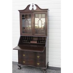 an old wooden desk with a mirror on it's top and drawers below the door