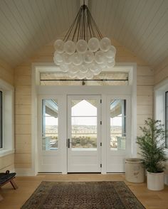 a white door with two windows and a rug on the floor in front of it