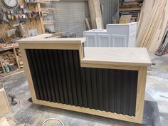 a wooden counter sitting on top of a floor next to other woodworking tools and supplies