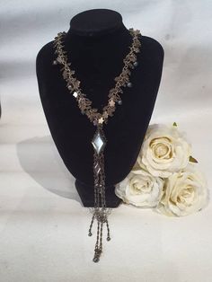 This is a beautiful Jacqueline Singh signed hand made in Paris necklace.  It features lovely silver plated flower charms, glass pearls and a beautiful diamond shaped mother of pearl pendant.  Jacqueline Singh jewelry becomes very sought after and collectable once being discontinued. The necklace is in excellent condition, and measures 14¼  inches and can be extended to 16 inches when wearing around the neck, and 17¾ inches when open. Dangle Long Metal Necklace As Gift, Elegant Long Dangle Necklace With Beaded Chain, Dangle Long Necklace As Gift, Elegant Long Necklace With Dangling Beads, Elegant Silver Lariat Necklace As Gift, Metal Long Dangle Necklace As A Gift, Elegant Long Dangle Beaded Necklace, Metal Dangle Long Necklace For Gift, Unique Silver Beaded Metal Necklace