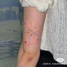 a woman's arm with a colorful star tattoo on it