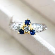 three stone ring sitting on top of a white cloth