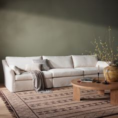 a living room filled with furniture and a rug on top of a wooden coffee table