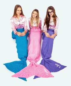 three girls dressed as mermaids posing for the camera