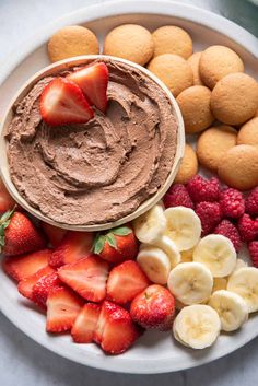 a white plate topped with fruit and chocolate dip