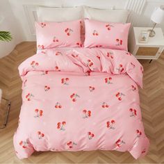 a pink bed with red flowers on it