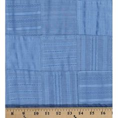 a ruler is next to a piece of blue fabric that has squares and lines on it