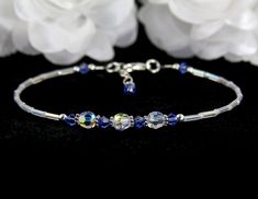 Something blue for the bride to wear on their wedding day. Enjoy this lovely, handmade blue wedding anklet. This custom wedding anklet is created with glistening clear rainbow clear and pearl seed beads, sapphire (aqua, light sapphire, sapphire, dark sapphire) Swarovski Austrian bicone crystals, perfectly round Swarovski beads, Bali .925 silver, and sterling silver. Accent Colors: Aqua, Sapphire (shown), Light Sapphire, Dark Sapphire Main Crystal Color: Crystal AB Anklet band: Rainbow clear and Adjustable Sapphire Bracelets For Wedding, Elegant Blue Anklets For Gifts, Elegant Blue Anklets For Gift, Adjustable Blue Crystal Bracelet For Wedding, Handmade Blue Crystal Wedding Bracelet, Adjustable Blue Crystal Bracelet For Anniversary, Adjustable Blue Beaded Bracelets For Wedding, Handmade Elegant Anklets For Wedding, Blue Beaded Anklets For Party