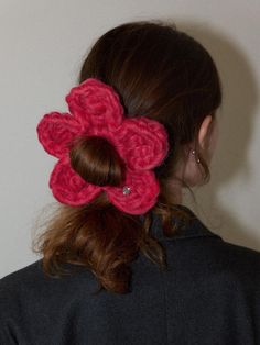 a woman with red hair wearing a crocheted flower in the back of her head