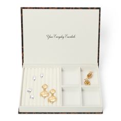 an open jewelry box with three pairs of earrings in it and the lid opened to reveal its contents