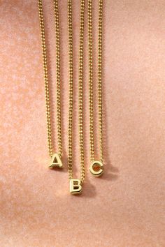 Choose your initial or a loved one's for an extra personal layer you'll love. We love wearing this gold alphabet necklace with dainty gold necklaces for a fully layered look. Dainty Yellow Gold Initial Necklace With Charms, Dainty 14k Gold Initials Charm Necklace, Classic Gold Jewelry With Letter Beads, Dainty Gold Charm Necklace With Letter Beads, Dainty Gold Initial Monogram Necklace, Minimalist Gold Charm Necklace With Letter Beads, Gold Minimalist Charm Necklace With Letter Beads, Minimalist Gold Charm Necklaces With Letter Beads, Dainty Gold Monogram Name Necklace