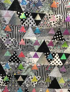 a quilt made with black, white and multicolored triangles