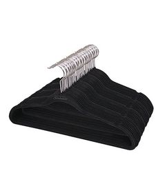 a pile of black sweaters hanging on a clothes hanger against a white background