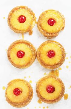 four pineapple cookies with cherries on top, arranged in the shape of circles