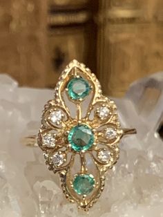 "This gorgeous ring is absolutely stunning! It features three central emeralds flanked by small diamonds and set in lustrous 14 karat yellow gold. The overall shape of the ring is reminiscent of a marquise shape. The green hue of these emeralds is so bright and cheerful and I love how the setting has such detail! This glorious cocktail ring will fit a size 6.5 to 6.75 finger, and weighs approximately 4.0 grams total. It is marked inside the band \"IJS 14 K\". This fabulous piece is in overall ve Emerald Ring White Gold, Emerald Birthstone Ring, Dainty Ruby Ring, Emerald Statement Ring, Princess Diana Ring, Diana Ring, Emerald Ring Vintage, Swarovski Crystal Rings, Leaf Engagement Ring