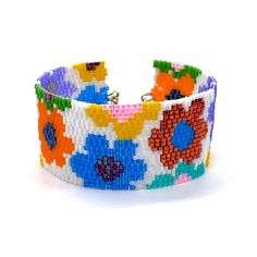 a bracelet made out of beads with colorful flowers on the front and back of it