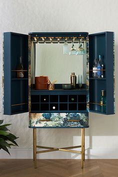 a blue cabinet with an open door and shelves filled with bottles on top of it