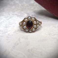 Vintage Garnet Birthstone Rings, Victorian Garnet Gemstone Rings, Vintage Oval Rings With Historical Design, Antique Cabochon Pearl Ring For Anniversary, Victorian Pearl Ring Gift, Victorian Pearl Ring Gemstone Gift, Victorian Style Pearl Ring Gift, Antique Pearl Ring With Cabochon For Anniversary, Victorian Pearl Ring With Gemstone For Gift