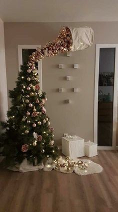 a decorated christmas tree sitting in the middle of a living room with presents on the floor