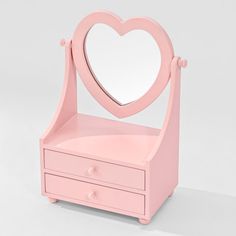 a pink vanity with a heart shaped mirror on it's top and drawers underneath