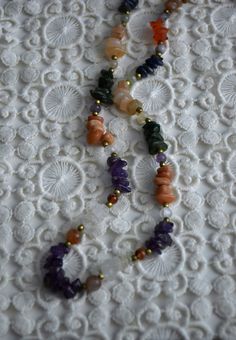 Vintage multicolored gemstone beaded necklace, featuring amethyst, carnelian, crystal quarts, onyx, agate. The necklace consists of one strand of stone chip beads, arranged by color with brass spacers between the different type of gemstones. Closes with screw barrel clasp at the back Era - 1980s Approx. Length (with clasp) - 24 inches / 61 cm Condition - Very good vintage condition, some dents on the stones! Vintage Gemstone Beads Jewelry For Healing, Vintage Gemstone Necklace For Healing, Vintage Healing Gemstone Necklace, Dainty Jewelry With Natural Stones For Healing, Amber Gemstones For Gifts, Dainty Round Gemstone Beaded Necklace, Spiritual Tumbled Agate Jewelry, Multicolor Natural Stones Crystal Necklace For Jewelry Making, Tumbled Gemstone Jewelry For Healing