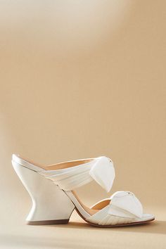 The Dee Ocleppo Burgundy Satin Bows Mule Sandals exude luxurious femininity with their rich satin and bold bow embellishments, making them the perfect statement footwear for any elegant occasion. | Burgundy Satin Bows Mule Sandals by Dee Ocleppo in White, Women's, Size: 40, Leather/Satin at Anthropologie Chic Cocktail Heels With Satin Bow, High Heel Cocktail Heels With Satin Bow, Summer Wedding Shoes In Satin With Closed Toe, Summer Wedding Shoes Satin Closed Toe, Summer Satin Wedding Shoes With Closed Toe, Evening Sandals With Satin Bow And Round Toe, Luxury Party Sandals With Satin Bow, Satin Closed Toe Heels With Bow, Luxury High Heels With Satin Bow