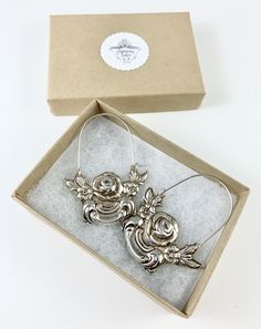 "These earrings are made from a vintage silver dish which had a beautiful embossed around the edge of flowers and other art nouveau motifs. I followed the line of the pattern into a point, drilled it and attached a sterling silver ear wire which is attached to either side of the charm. One side is hooked and unloops from the other side for you to insert the ear wire, and then clip it back up. They are very lightweight but are so eye catching. Measurements: Charm Length: 53 mm / 2.08\" Charm Widt