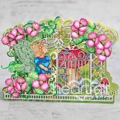 a card with an image of a fairy sitting on a fence and flowers surrounding it