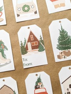 christmas gift tags with pictures of houses, trees and cars on them are laid out on a table