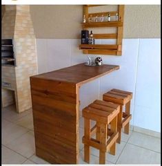 a small bar made out of wood with stools and shelves on the wall behind it