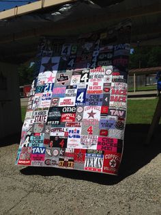 a quilt made out of various stickers on the ground next to a picnic table