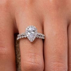 a woman's hand with a diamond ring on top of her finger and an engagement band