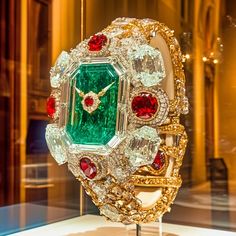 This striking second piece in the Dazzle Time collection radiates pure extravagance with a bold combination of emeralds, rubies, and diamonds, intricately crafted to resemble an ultra-luxurious watch. The oversized emerald centerpiece, surrounded by radiant diamonds and ruby accents, transforms the traditional idea of a timepiece into a dazzling work of art. The gold details and intricate settings evoke a sense of timeless grandeur, making this digital creation a stunning celebration of opulence. Welcome to my high-concept art for the wall, shelf, Digital Picture frame, or computer desktop wallpaper.  Art Description: Imperial Jewel commands attention with its resplendent emerald face, reminiscent of the grand treasures of empires past. The immense central emerald is framed by flawless dia Watch Concept Art, Watch Concept, Extravagant Jewelry, Intricate Jewelry, Luxurious Watch, Famous Jewelry, Rubies And Diamonds, Digital Picture Frame, Computer Wallpaper Desktop Wallpapers