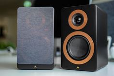 two speakers sitting next to each other on top of a white table with a computer in the background